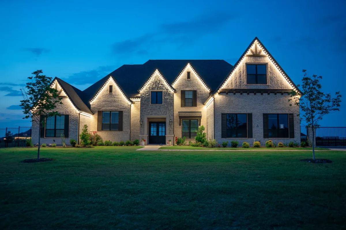 Suburban home illuminated at twilight with permanent warm white LED rooflines